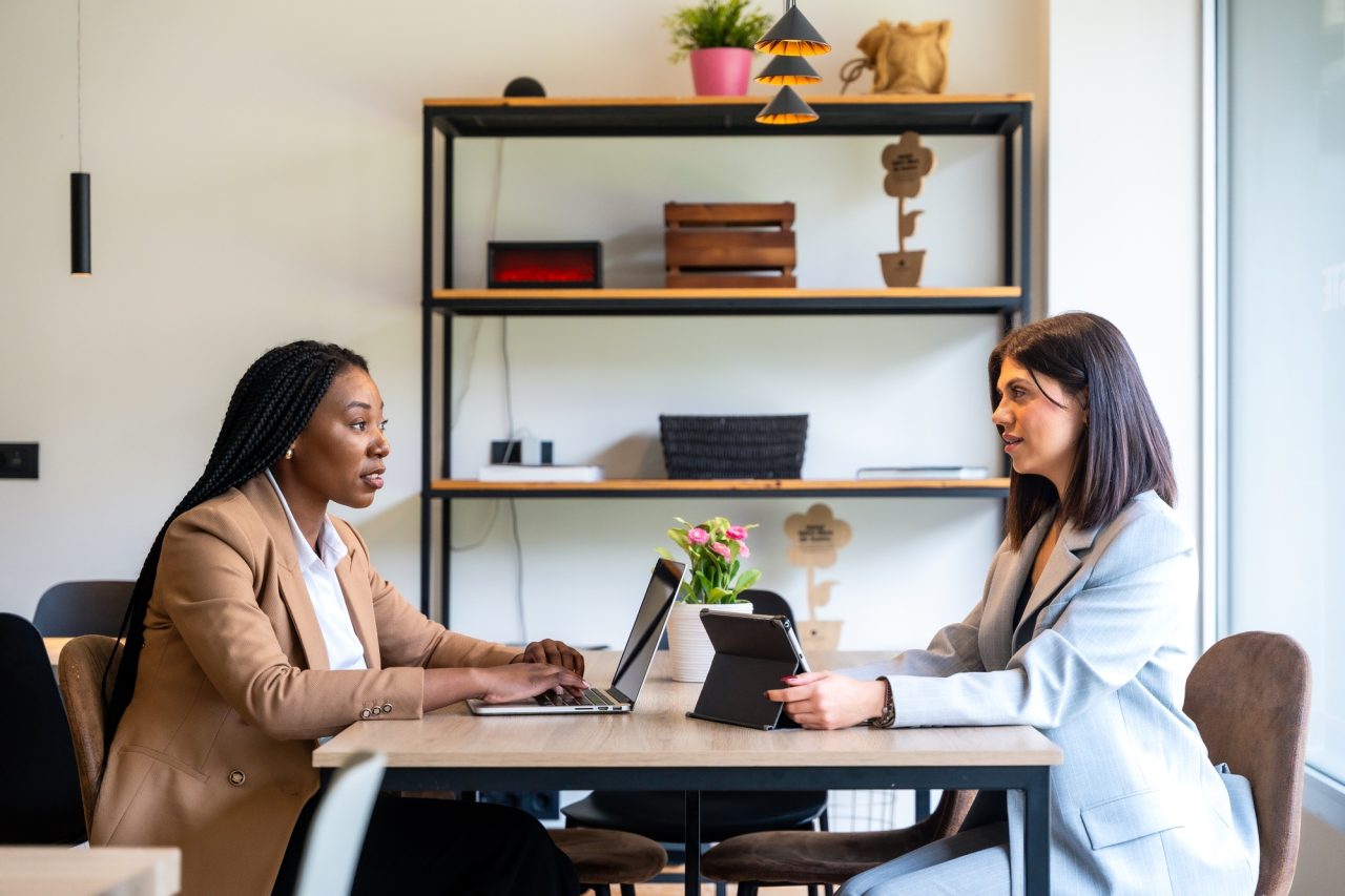 businesswomen working on laptops and digital tablets in hotel lobby.jpg